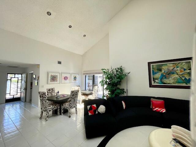 tiled living area featuring high vaulted ceiling