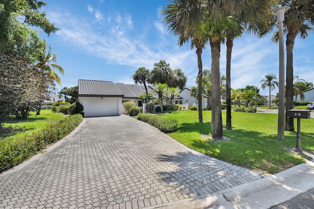 14 Windsor Ln, Boynton Beach, FL 33436 - view of front facade featuring decorative driveway, an attached garage, a front lawn, stucco siding, and a tile roof