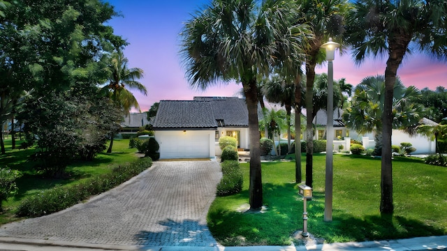 14 Windsor Ln, Boynton Beach, FL 33436 - view of front facade featuring a garage, decorative driveway, a yard, stucco siding, and a tile roof