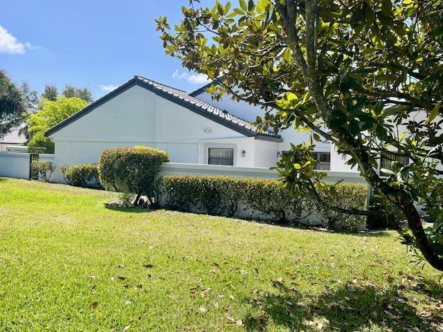 view of property exterior featuring a lawn and stucco siding