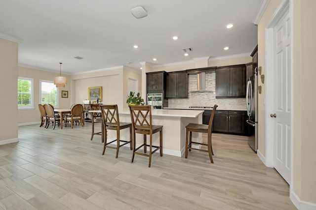1055 Ember Ridge Run, Loxahatchee, FL 33470 - kitchen with a breakfast bar area, light countertops, tasteful backsplash, recessed lighting, and light wood-type flooring