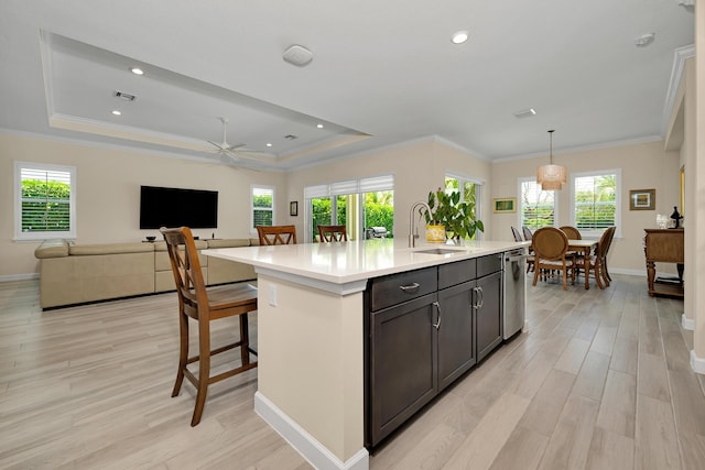 1055 Ember Ridge Run, Loxahatchee, FL 33470 - kitchen with a sink, dishwasher, light countertops, light wood finished floors, and a raised ceiling