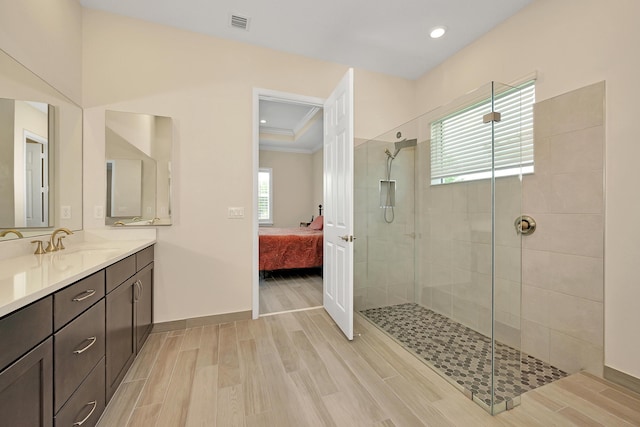 1055 Ember Ridge Run, Loxahatchee, FL 33470 - bathroom featuring connected bathroom, wood finished floors, a tile shower, crown molding, and vanity