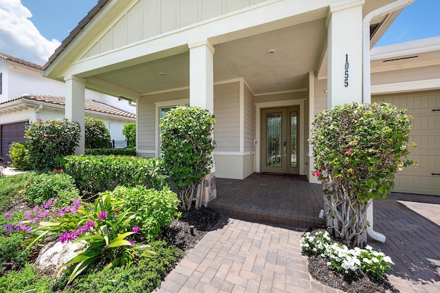 1055 Ember Ridge Run, Loxahatchee, FL 33470 - doorway to property with board and batten siding, french doors, and a porch