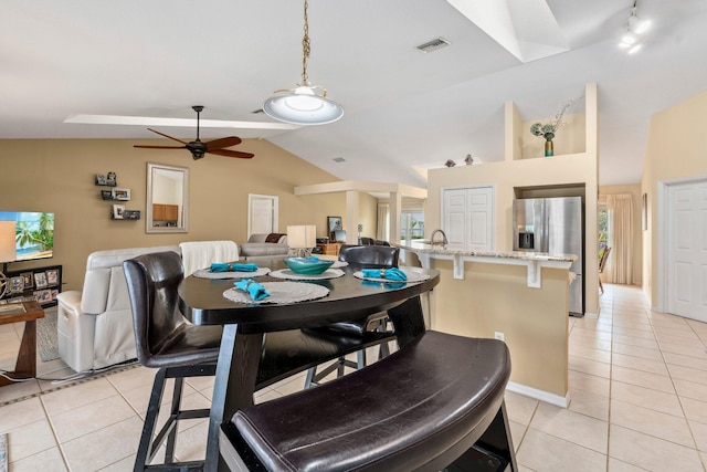 dining area featuring lofted ceiling, baseboards, ceiling fan, visible vents, and light tile patterned flooring