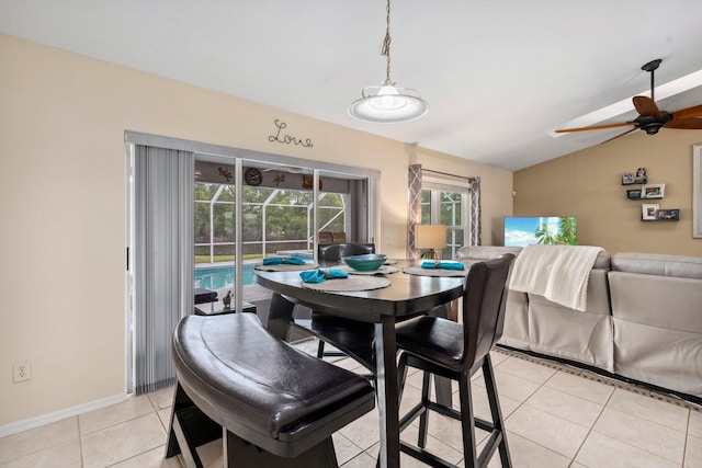 dining room with a ceiling fan, light tile patterned floors, baseboards, and lofted ceiling