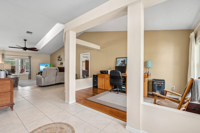 office with light tile patterned flooring, visible vents, vaulted ceiling, a ceiling fan, and baseboards