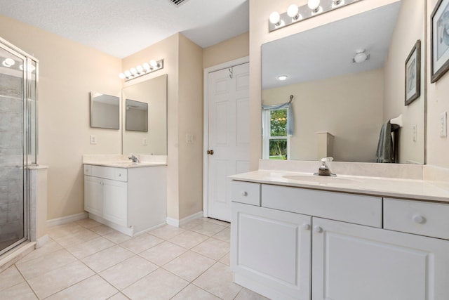 full bath featuring a sink, tile patterned flooring, two vanities, and a shower stall