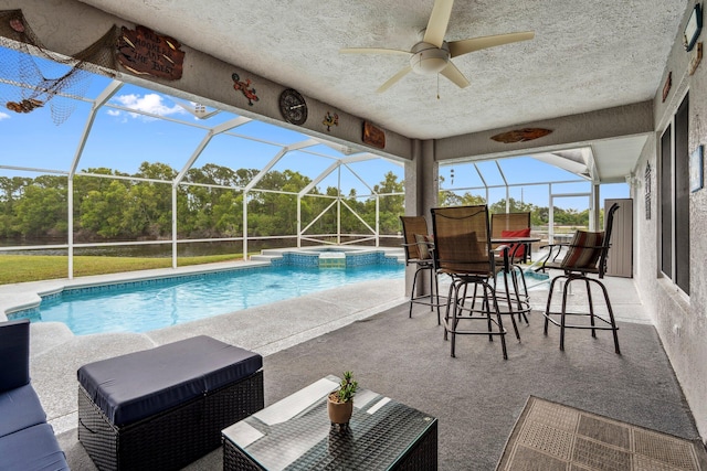 view of swimming pool with a ceiling fan, glass enclosure, and a patio