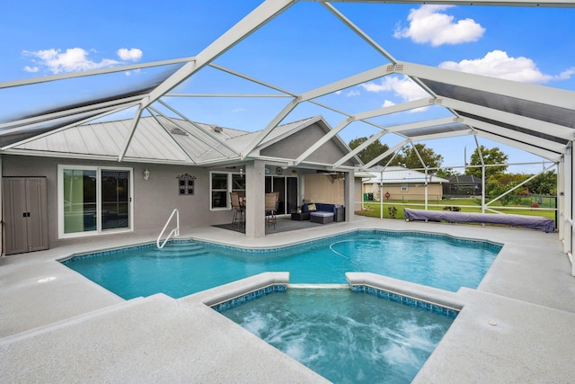 view of pool featuring outdoor lounge area, a patio area, a pool with connected hot tub, and a lanai