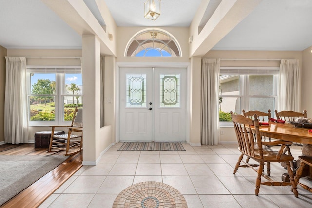 foyer entrance featuring baseboards and light tile patterned flooring