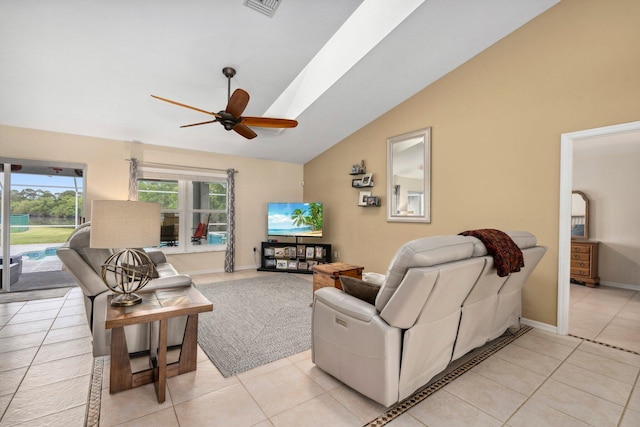 living area with lofted ceiling, visible vents, a ceiling fan, light tile patterned floors, and baseboards