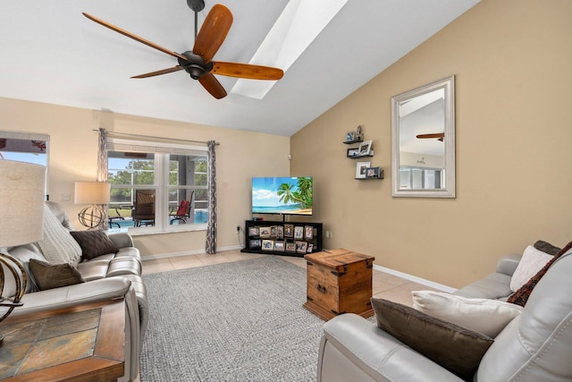 living area with a ceiling fan, baseboards, tile patterned floors, and vaulted ceiling