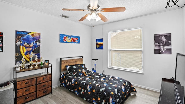 bedroom with visible vents, a textured ceiling, and wood finished floors
