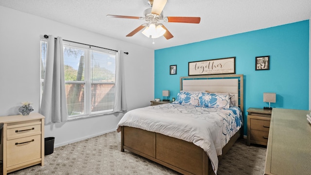 bedroom featuring a ceiling fan, baseboards, light carpet, and a textured ceiling
