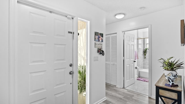 foyer entrance with baseboards and light wood-type flooring