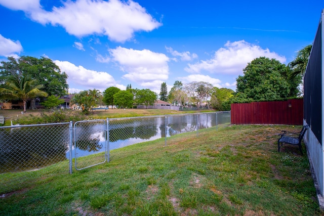 view of yard with a water view and a fenced backyard