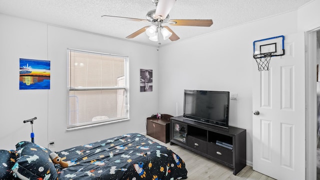 bedroom featuring a ceiling fan, a textured ceiling, and light wood-style floors