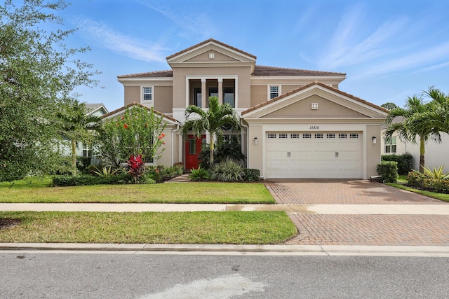 15816 Orchard Dr, Westlake, FL 33470 - mediterranean / spanish home featuring a tile roof, a front yard, a garage, decorative driveway, and stucco siding