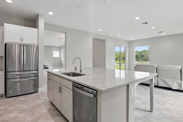 15816 Orchard Dr, Westlake, FL 33470 - kitchen with a sink, stainless steel appliances, a center island with sink, light stone counters, and open floor plan