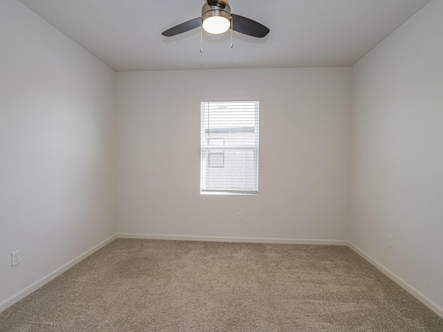 carpeted spare room with ceiling fan and baseboards