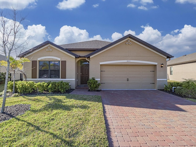 view of front facade with a front lawn, decorative driveway, stucco siding, and a garage