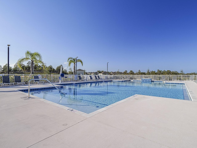 community pool featuring fence and a patio area