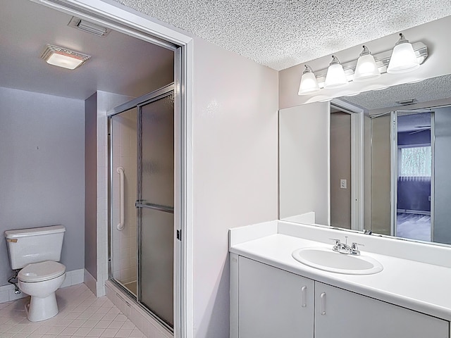 full bath featuring vanity, toilet, a stall shower, a textured ceiling, and tile patterned flooring