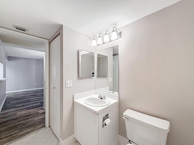 bathroom featuring baseboards, visible vents, toilet, and vanity