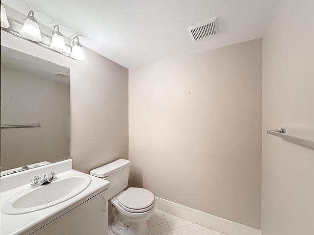 half bath featuring visible vents, toilet, and vanity