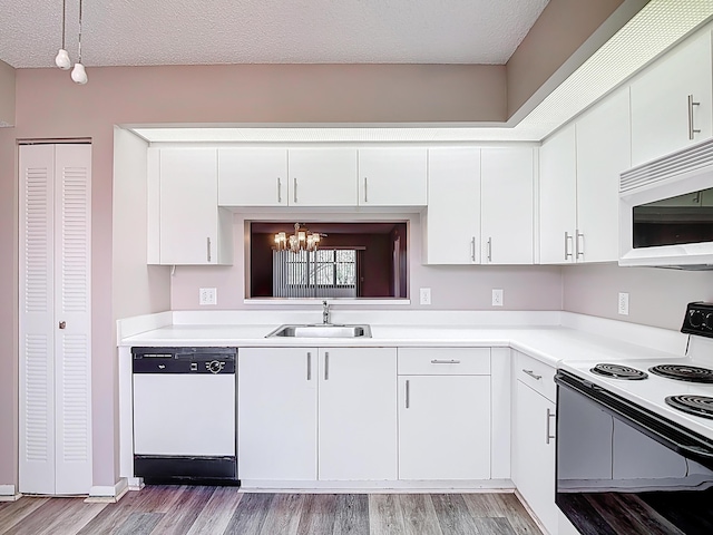 kitchen with light wood finished floors, an inviting chandelier, a sink, white appliances, and white cabinets
