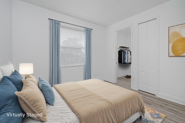 bedroom featuring baseboards, a closet, and light wood-style flooring