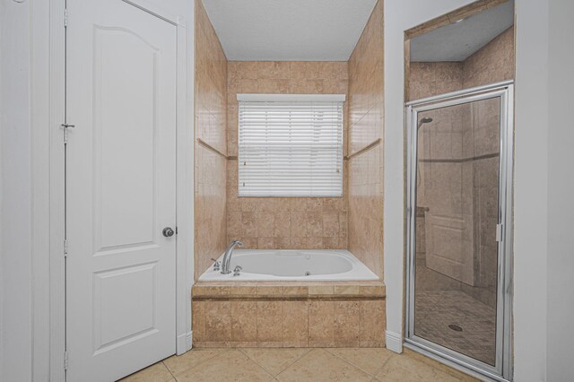 bathroom featuring a stall shower, tile patterned flooring, and a bath