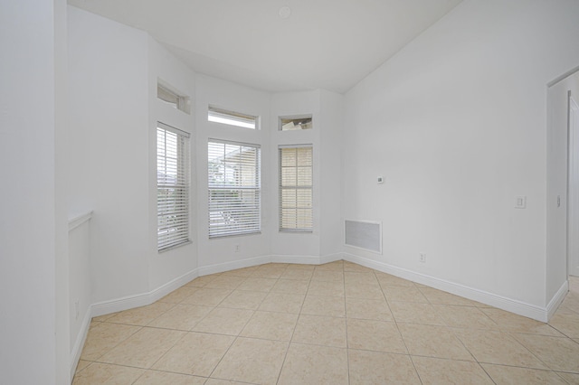 empty room featuring light tile patterned floors, visible vents, and baseboards