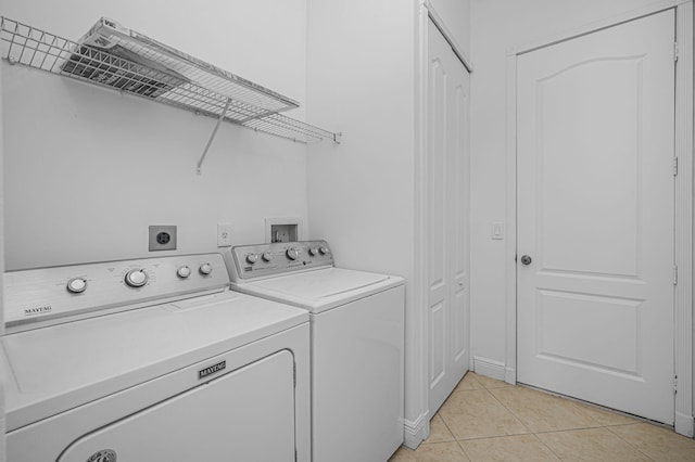 laundry area featuring light tile patterned floors, separate washer and dryer, and laundry area