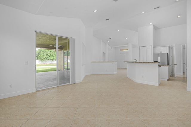 unfurnished living room featuring light tile patterned floors, recessed lighting, high vaulted ceiling, and baseboards