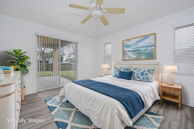 bedroom with wood finished floors, baseboards, access to outside, and multiple windows