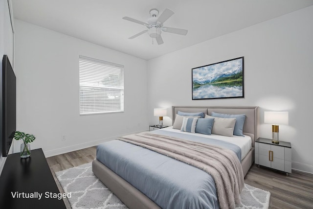 bedroom with a ceiling fan, wood finished floors, and baseboards