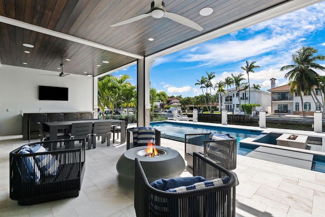 view of patio featuring an outdoor fire pit, a hot tub, area for grilling, a ceiling fan, and an outdoor pool