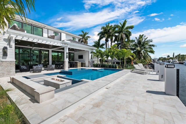 view of swimming pool featuring a fire pit, ceiling fan, area for grilling, a pool with connected hot tub, and a patio area