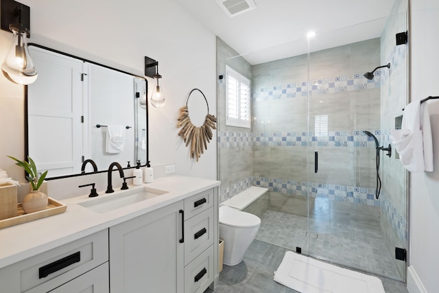 bathroom featuring toilet, a stall shower, visible vents, and vanity