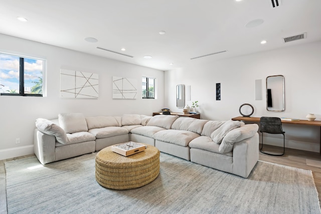living room with recessed lighting, visible vents, wood finished floors, and baseboards
