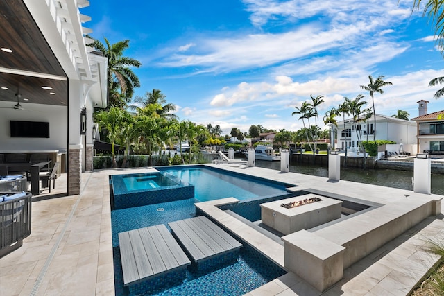 view of swimming pool featuring a pool with connected hot tub, a patio area, an outdoor fire pit, a water view, and ceiling fan