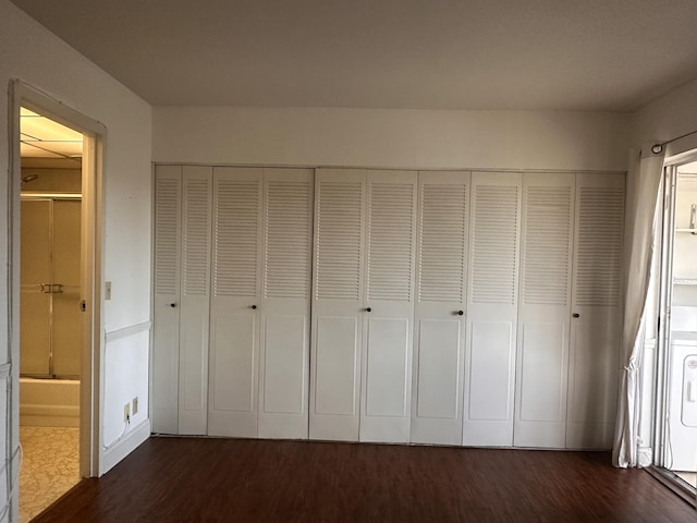 363 Monaco H, Delray Beach, FL 33446 - unfurnished bedroom featuring dark wood-type flooring, connected bathroom, and a closet