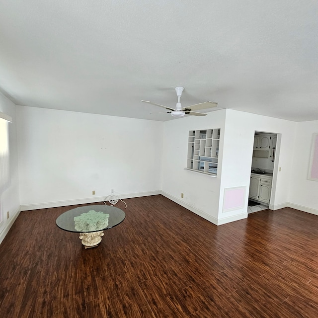 363 Monaco H, Delray Beach, FL 33446 - unfurnished living room with dark wood-type flooring, baseboards, and ceiling fan