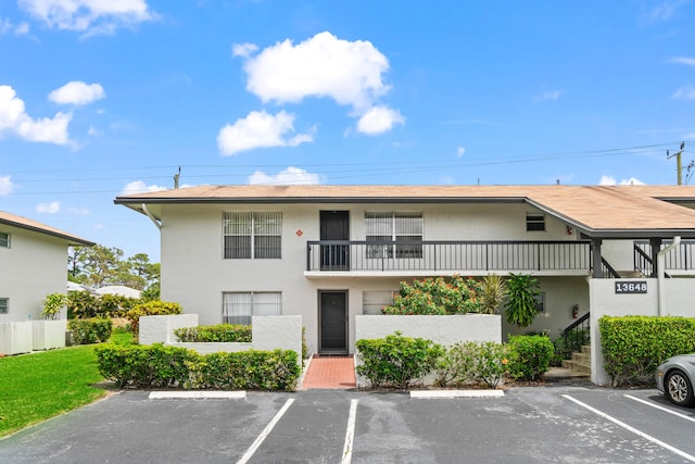 13648 Coconut Palm Ct Unit B, Delray Beach, FL 33484 - view of property featuring fence, stairs, and uncovered parking
