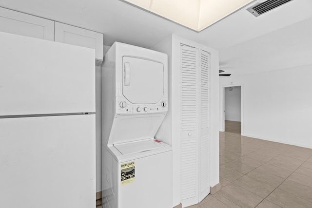 13648 Coconut Palm Ct Unit B, Delray Beach, FL 33484 - laundry area featuring stacked washer and dryer, light tile patterned floors, visible vents, baseboards, and laundry area