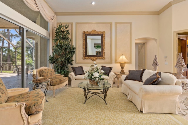 living area featuring recessed lighting, ornamental molding, and arched walkways