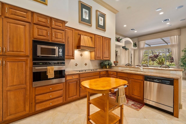 kitchen with visible vents, appliances with stainless steel finishes, a sink, premium range hood, and a peninsula