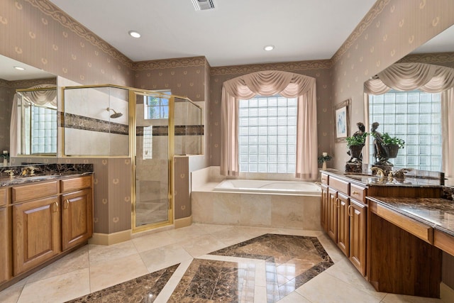 bathroom with wallpapered walls, two vanities, a garden tub, and a stall shower